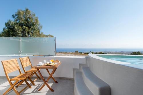 a patio with a table and chairs next to a swimming pool at Anamnesis City Spa in Fira