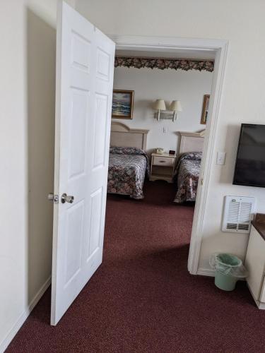 a room with two beds and a white door at Lighthouse Inn in Crescent City