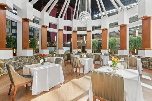 a dining room with tables and chairs in a building at The Armon Stamford Hotel & Conference Center in Stamford