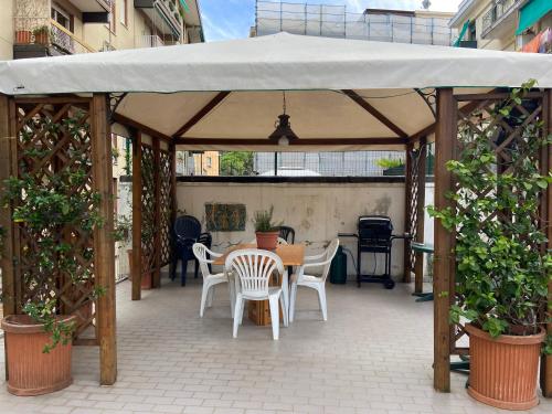 einen hölzernen Pavillon mit einem Tisch und Stühlen auf einer Terrasse in der Unterkunft SUNNY APARTMENT with big terrace in Rapallo