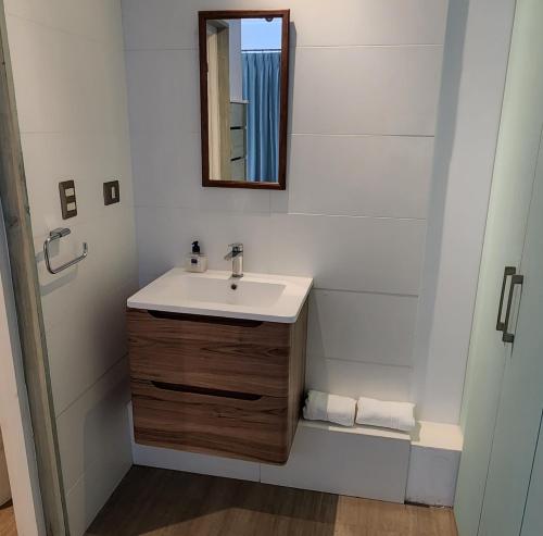 W łazience znajduje się umywalka i lustro. w obiekcie Apart Hotel Rapa Nui w mieście Hanga Roa