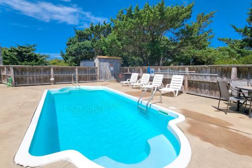 a swimming pool on a patio with chairs and a table at Sun Phun #10HH in Hatteras