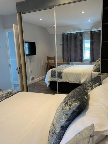 a hotel room with two beds and a mirror at Luxury 3 Bedroom Apartment with Large Garden in Welling