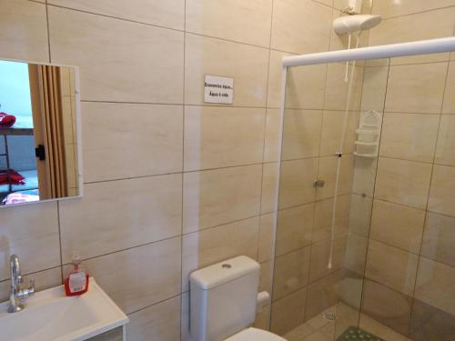 a bathroom with a shower and a toilet and a sink at Pousada JOSHUA in Penha