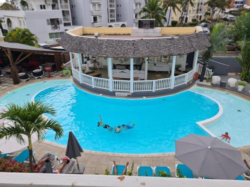 una piscina en un hotel con gente nadando en ella en Le Bellissima, en Saint-Gilles-les-Bains