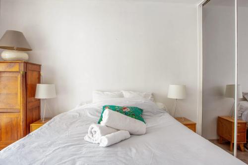 une chambre avec un lit blanc avec des serviettes dessus dans l'établissement Appartement Solférino - Welkeys, à Boulogne-Billancourt