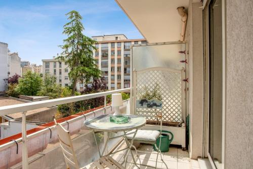 uma varanda com uma mesa e cadeiras e uma janela em Superb apartment with balcony - Boulogne-Billancourt - Welkeys em Boulogne-Billancourt