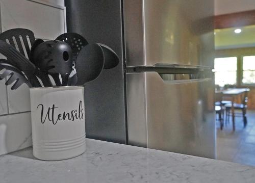 a container of kitchen utensils sitting on a counter next to a refrigerator at St Lawrence River Retreat in Ogdensburg
