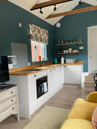 a kitchen with a sink and a counter top at Cockloft Romantic Countryside Hideaway in Bishops Cannings