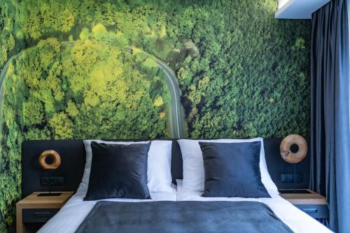 a bedroom with a bed and a green wall at 4 Évszak Erdeihotel**** - Mátrafüred in Mátrafüred