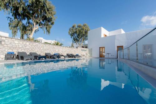 a swimming pool with chairs and a house at Anamnesis City Spa in Fira