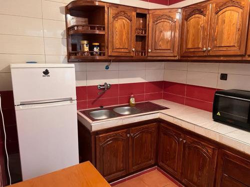 uma cozinha com um frigorífico branco e um lavatório em 2 Zimmer Wohnung Corniche Nador Sidi Ali- am Meer & Wifi em Nador