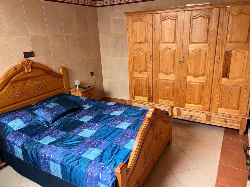 a bedroom with a wooden bed and wooden cabinets at 2 Zimmer Wohnung Corniche Nador Sidi Ali- am Meer & Wifi in Nador