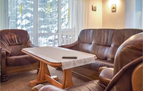 a living room with two leather chairs and a coffee table at Lovely Home In Sokole Kuznica in Sokole-Kuźnica
