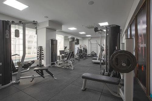 a gym with a bunch of equipment in a room at QOYA Hotel Curitiba, Curio Collection by Hilton in Curitiba