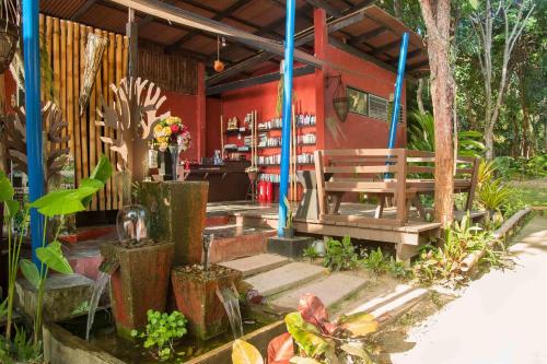 a red building with a bench and a table at LaLaanta Hideaway Resort in Ko Lanta