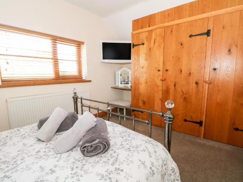 a bedroom with a bed with two towels on it at Ash Farm Cottage in Holywell