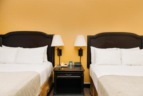 a hotel room with two beds and a table with two lamps at Plaza Hotel and Suites in San Salvador