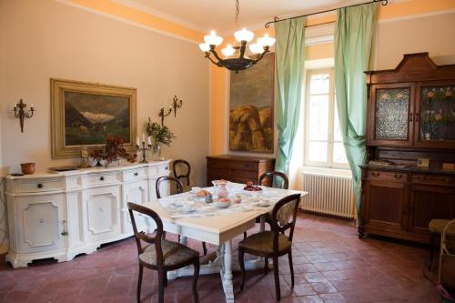a dining room with a white table and chairs at Agriturismo Azienda Agricola Mombisaggio in Tortona