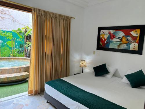 a bedroom with a bed and a large window at Hotel Primavera Santa Fe in Santa Fe de Antioquia
