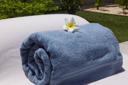 un asciugamano blu con un fiore sopra di Au Paradis de Jeanne a Ngaparou