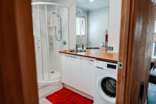 a bathroom with a sink and a washing machine at Unwind in Paradise Valley Trout at your door in Rotorua