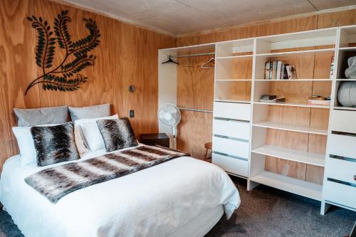 a bedroom with a bed and book shelves at Unwind in Paradise Valley Trout at your door in Rotorua