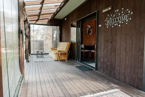 a screened in porch with a couch on a deck at Unwind in Paradise Valley Trout at your door in Rotorua