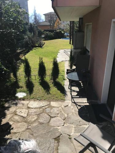 a patio with a bench and a grass yard at Locarno: camera indipendente in zona residenziale in Locarno