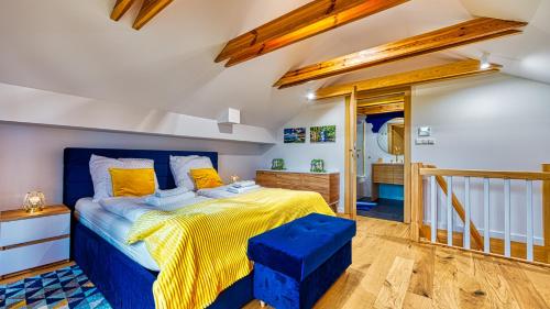 a bedroom with a blue bed with yellow sheets at Apartament Penthaus Dwupoziomowy z Klimatyzacją i 2 Łazienkami - 5D Apartamenty in Karpacz