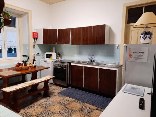 a kitchen with a sink and a refrigerator and a table at QM - Quinta da Morgadinha - Casa em Quinta Rural in Cabeços
