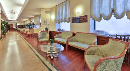 a waiting room with chairs and a table in a hospital at Hotel Mirage Sure Hotel Collection by Best Western in Milan