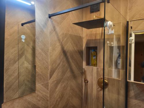 a shower with a glass door in a bathroom at Studio Żelazna - Apartment near Old Town in Warsaw