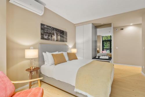 a bedroom with a white bed and a chair at 108MM House in Porto