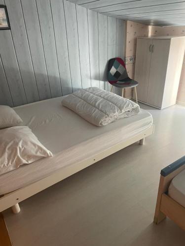 un lit dans une chambre avec un mur en bois dans l'établissement La belle Vendéenne, à La Tranche-sur-Mer