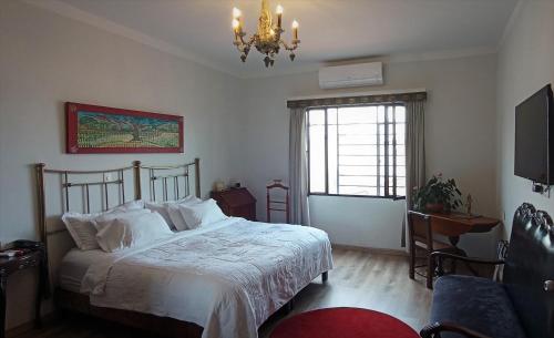 um quarto com uma cama e um lustre em Hotel Don Alfonso em Pereira