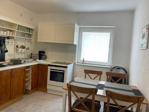 une cuisine avec une table et une cuisinière four supérieur dans l'établissement TOP Lage in Rostock 3 Zimmer Wohnung mit bestem Ausblick im 1 OG rechts, à Rostock