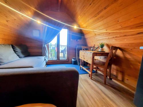 Habitación con sofá y escritorio. en The Golden Ball Luxury Pods en Morecambe