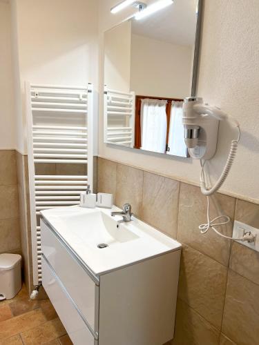 y baño con lavabo blanco y espejo. en Villa sulle colline del Prosecco - Casa di Gaia, en Follina