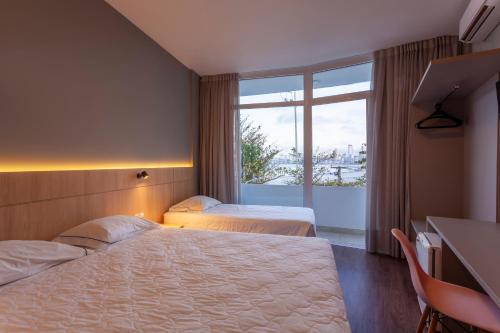 um quarto de hotel com duas camas e uma janela em Marambaia Hotel e Convenções em Balneário Camboriú
