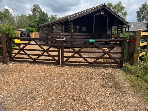 a wooden gate in front of a house at Cheerful 3-bedroom cabin with hot tub in King's Lynn
