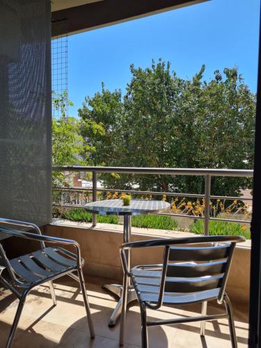 two chairs and a table on a balcony at Aires Verdes de Capital Depto in Salta