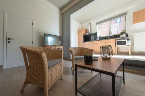 een woonkamer met een tafel en stoelen en een keuken bij Vakantiewoningen Pomona in Heers