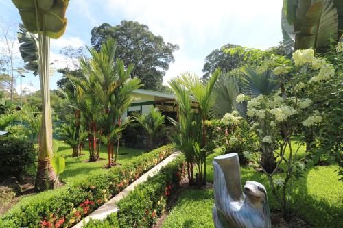a garden with a statue in front of a house at New Caribe Point in Cahuita