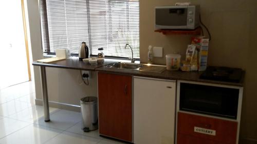 una cucina con bancone, lavandino e forno a microonde di Bettie's Luxury Lodge a Kroonstad