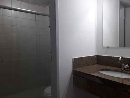 a bathroom with a sink and a mirror and a shower at Suíte aconchegante no Centro de Campos WIFI Liberado in Campos dos Goytacazes