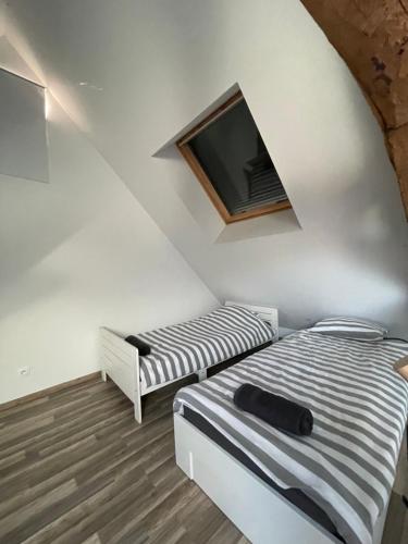 a bedroom with two beds and a tv on the wall at Loft Chez Guillaume in Bouleurs