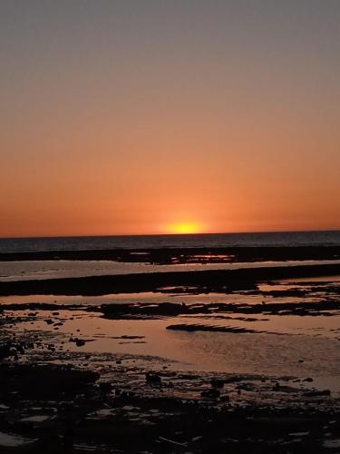 a sunset over the ocean with the sun setting at Nuevo Jerez in Jerez de la Frontera