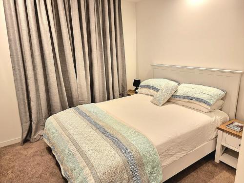 a bedroom with a bed and a window with curtains at Maroochy City Lights@Thecosmopolitan Unit 20802 in Maroochydore