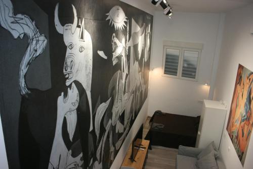 a living room with a large painting on the wall at Golondrinas de Malaga "Apartamentos con mucho Arte" y terraza solarium en coliving in Málaga